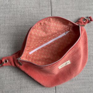 Sac banane en velours corail avec une poche intérieure et une bandoulière amovible